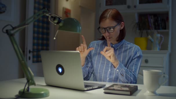 Jovem de 30 anos professora de óculos conversando e gesticulando emocionalmente olhando para laptop em casa. Processo de educação online. Trabalho em casa — Vídeo de Stock