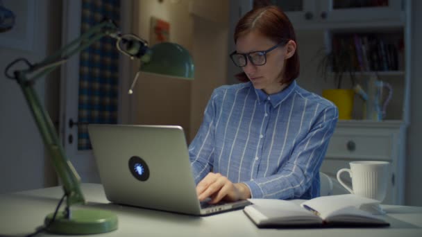 30 Satisfecho trabajando desde casa mujer escribiendo en el ordenador portátil y sonriendo. Proceso de educación en línea. Empresaria en gafas en casa . — Vídeo de stock