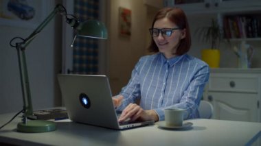30 'lu yaşlardaki genç bir kadın, bilgisayarını kapatıp bir fincan kahve içmeyi evde bitiriyor. Kadın sıcak içkinin tadını çıkarmak için evde mola veriyor.. 