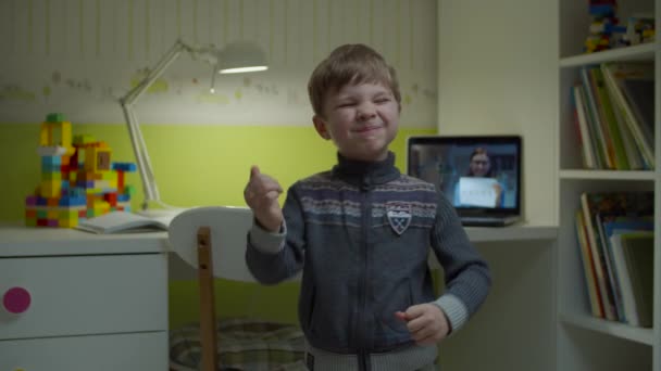 Kleuterjongen dansend thuis met online les met lerares op laptop achter. E-studeren gelukkig kind dansen op kinderkamer. — Stockvideo