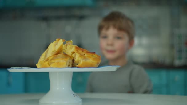 Apple charlotte pie on plate and preschooler boys head appearing from the table on the kitchen. 배고픈 애가 사과 케이크먹고 싶어 해. — 비디오