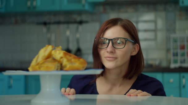 Torta di charlotte di mele sul piatto e testa di donna degli anni '30 che appare dal tavolo in cucina. La persona affamata vuole mangiare torta di mele a casa . — Video Stock