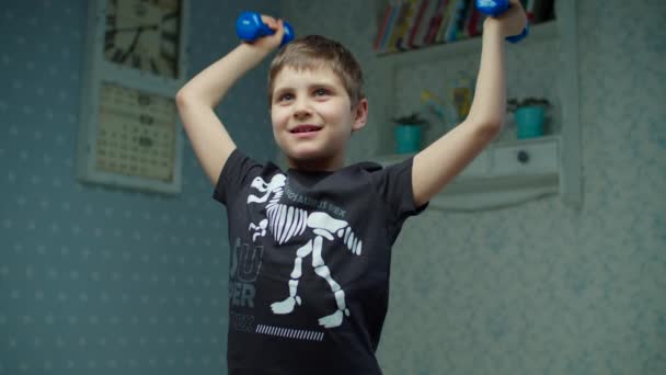 Schuljunge, der zu Hause komplexe Fitnessübungen macht. Kind macht Spaß mit Hanteln in Zeitlupe. — Stockvideo