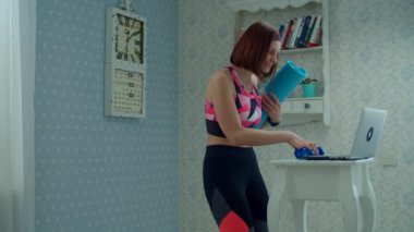 Spor kıyafetleri içinde 30 'lu yaşlarda, elinde halterlerle dizüstü bilgisayara geliyor ve yavaş çekimde spor salonuna başlıyor.. 