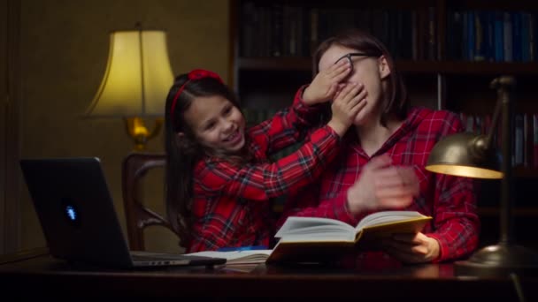 Familie schauen, wie Mutter und Tochter Spaß haben, während sie zu Hause Hausaufgaben machen. Schulmädchen und Frau lachen. Heimerziehungsprozess. — Stockvideo