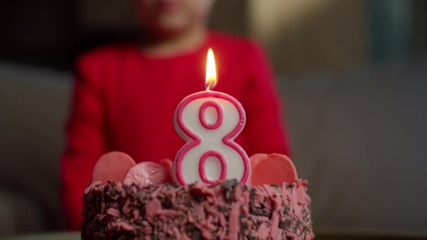 Close up de criança soprando vela com o número 8 no bolo de aniversário de chocolate em câmera lenta. Menina de oito anos celebra aniversário . — Vídeo de Stock