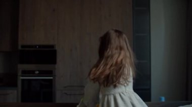 İki anaokulu çocuğu karanlık odadaki kanepede zıplayıp gülüyor. Genç kız, kanepede kardeşiyle eğleniyor.. 