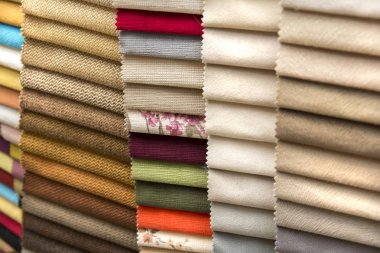 Raf üzerinde yığılmış renkli kumaşlar