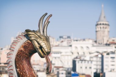 Eminönü sahil şeridi, Galata Kulesi teknede satan bir balık şeklinde Dragon kukla vasıl geçmiş görülebilir. Istanbul, Türkiye.