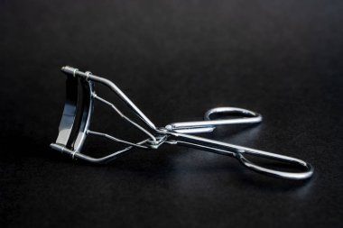 Kirpik kıvırıcı Koyu bir yüzeye yerleştirilmiş