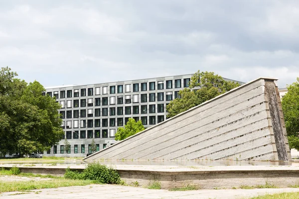 Ağaçlı ve arka planda bir bina bulunan anıtın düşük açılı görüntüsü