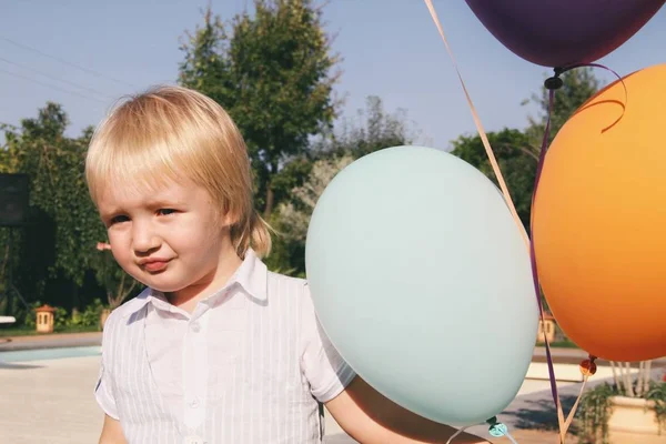 Portrait of little caucasian boy in casual clothes in home garden