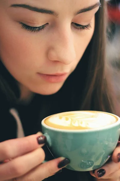 Giovane donna caucasica che si gode il caffè bevendo in caffè, da vicino — Foto Stock