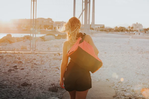 Woman on her backs walking with a sports bag on the shoulder. Sp — Stock Photo, Image