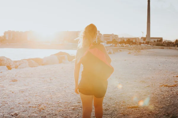 Woman on her backs walking with a sports bag on the shoulder. Sp — Stock Photo, Image