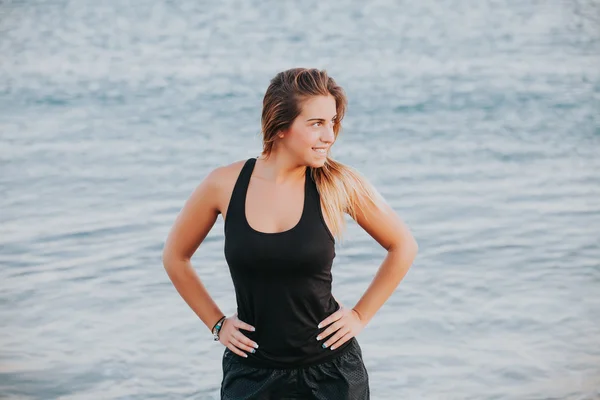 Donna bionda in abbigliamento sportivo, con l'ocea sullo sfondo . — Foto Stock