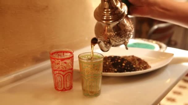 Woman holding a teapot and serving arabic tea in two glasses — Stock Video