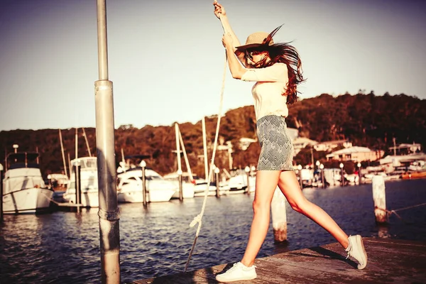 Mooi meisje slingeren met een touw in de haven van vrije tijd. Fashion concept. — Stockfoto