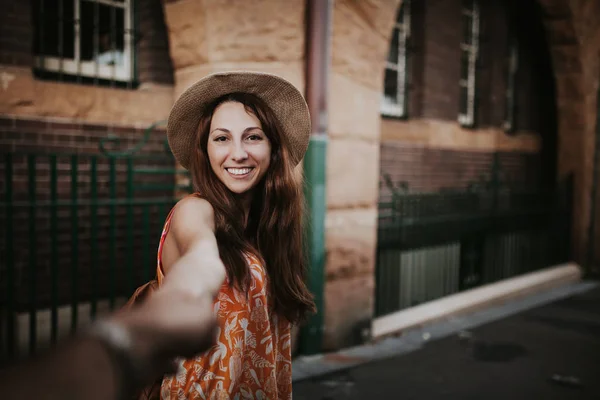 Woman holding boyfriend hand, while taking a photo of her. — Stock Photo, Image