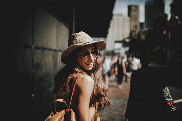 Souriant femme heureuse marchant dans une rue de Sydney et se retournant pour regarder la caméra . — Photo