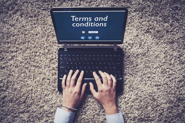 Términos y condiciones en una pantalla portátil. Manos de mujer escribiendo en el teclado . — Foto de Stock