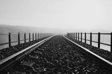 Tren sabah sisin içinde kaybolan bir köprü üzerinde.