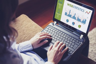 Web istatistik danışmanlığı. Web istatistikleri çözümlemek için bir dizüstü bilgisayar kullanan kadın.