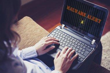 Malware alert in a laptop computer. clipart