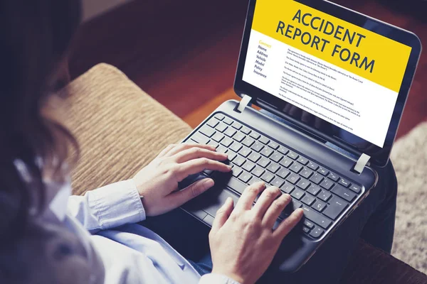 Γυναίκα, συμπληρώστε μια φόρμα έκθεσης ατυχήματος με έναν φορητό υπολογιστή από το internet. — Φωτογραφία Αρχείου