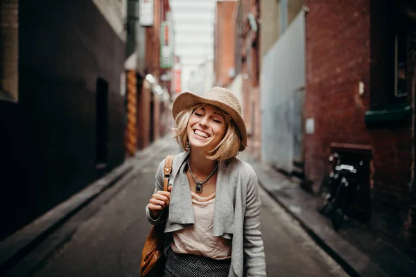 Retrato da vida urbana de mulher sorridente no meio de uma rua estreita . — Fotografia de Stock