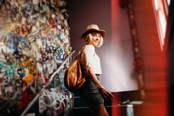 Femme heureuse qui monte des escaliers dans un bâtiment générique de la ville. Effet de lumière créatif . — Photo