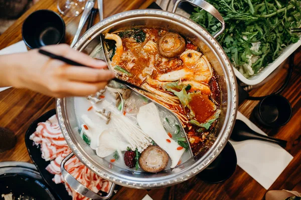 Korean hot pot meal. Hands taking food with chopsticks. — Stock Photo, Image