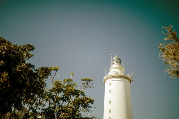 Faro blanco en medio de la naturaleza entre los árboles. Efecto vintage . — Foto de Stock