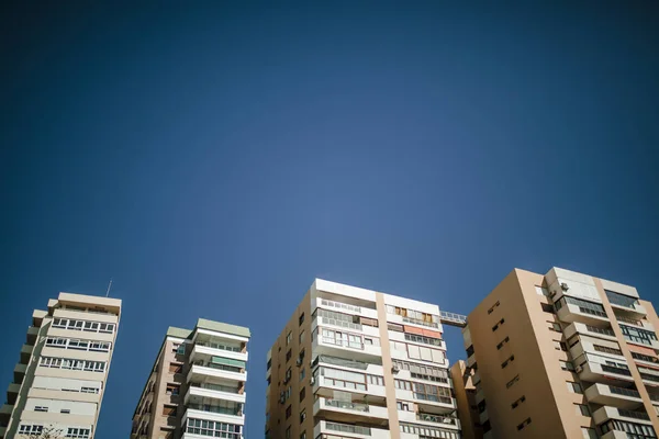 Vue à angle bas des immeubles d'appartements génériques, avec ciel bleu en arrière-plan . — Photo