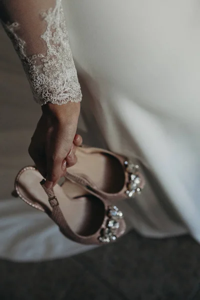 Sposa che tiene in mano un paio di scarpe da sposa . — Foto Stock