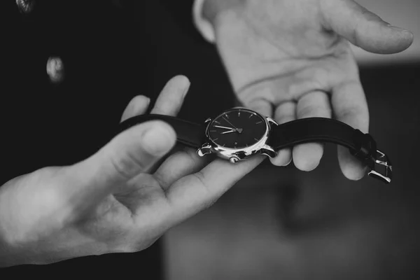 Un hombre sosteniendo un reloj en las manos. Blanco y negro . — Foto de Stock