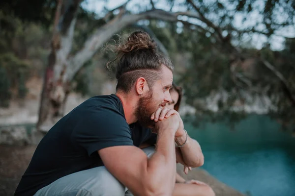 Homem barbudo sentado com sua namorada no meio da natureza — Fotografia de Stock