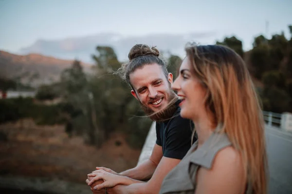 Porträt eines bärtigen Mannes, der lacht, während er seine Freundin im Freien ansieht — Stockfoto