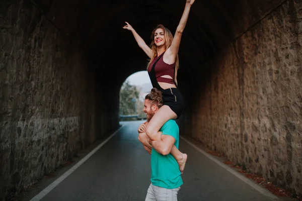 Homem carregando sua namorada em seus ombros. Casal alternativo — Fotografia de Stock