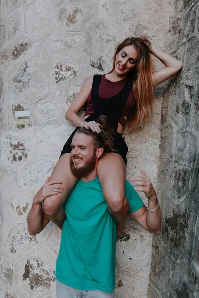 Um casal giro. Homem segurando-a em seus ombros enquanto ela olha para ele . — Fotografia de Stock