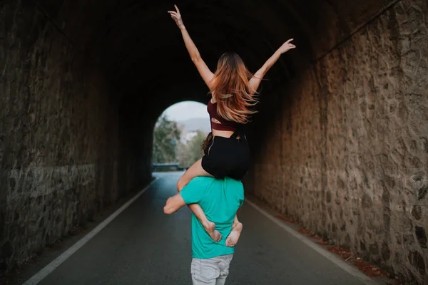 Homem carregando sua namorada em seus ombros. Casal alternativo — Fotografia de Stock