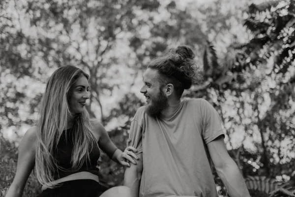 Szczęśliwa para alternatywnych, śmiejąc się razem siedząc w przyrodzie — Zdjęcie stockowe