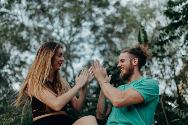 Couple heureux jouant ensemble avec les mains tout en riant dans la nature — Photo