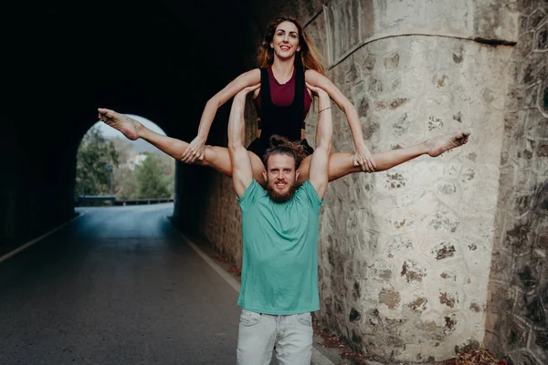 Homem segurando e elevando mulher com os braços em uma dança de ginástica — Fotografia de Stock