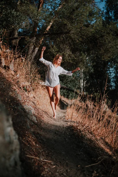 Mujer descalza caminando y bailando por sendero angosto en la naturaleza . — Foto de Stock