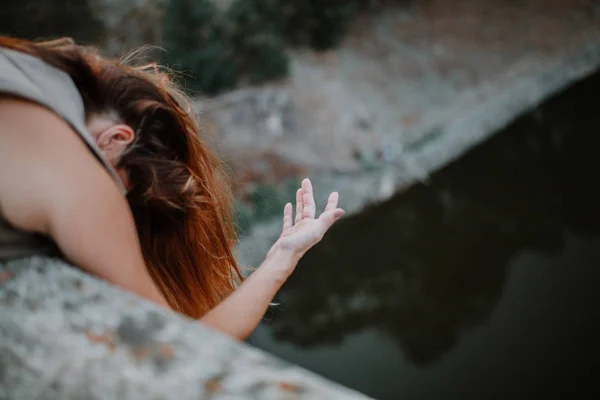 Frau hängt Hand von einer Brücke in die Luft — Stockfoto