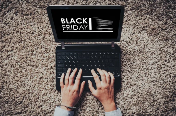 Black Friday reklame i en bærbar skærm, mens kvinden bruger det til shopping via internettet . - Stock-foto