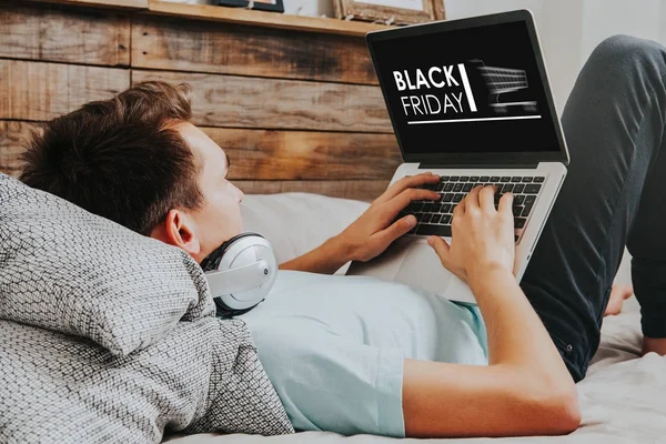 Mand, der bruger en bærbar computer til at købe i en Black Friday shopping særlige web - Stock-foto
