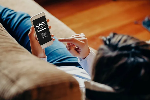 Mujer usando un teléfono móvil para comprar en el Viernes Negro ofertas especiales . — Foto de Stock