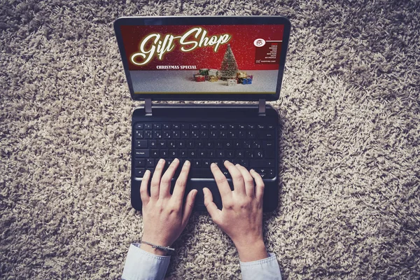 Vue du dessus de l'ordinateur portable avec cadeau de Noël sur la boutique en ligne à l'écran avec des mains de femme tapant . — Photo